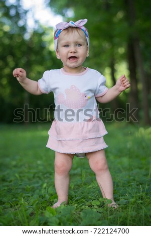 first steps of little girl in summer green park