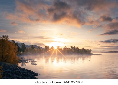 First sun rays hit mountain above the lake. Lulealven lake in Stora Sjofallet national park, Kebnats, Sweden