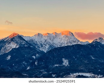 First sunrise sunlight on majestic snow-capped mountain summit Mittagskogel in Karawanks seen from Rosental, Carinthia, Austria. Alpine winter wonderland landscape at night in serene Austrian Alps - Powered by Shutterstock