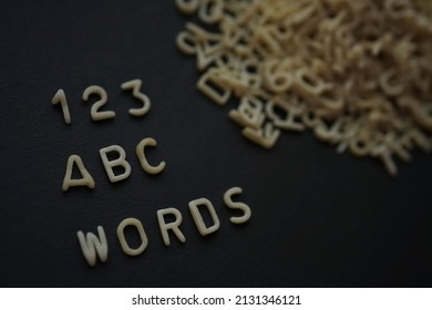 First writing lesson. Pasta in the form of abc letters and 123 digits. Words. 