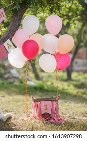 first year baby girl's birthday party day. ballons and holiday outdoors. child's birthday with cake and decorations