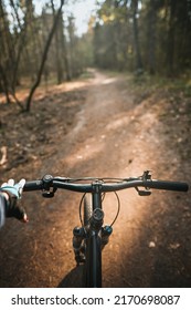 First-person View Bicycle Riding. Man Riding A Bike. Holding Bike Handlebar With One Hand In Sport Glove. Summertime Outdoor Leisure Sport Activity. Close Up Of Bicycle Handle Bar