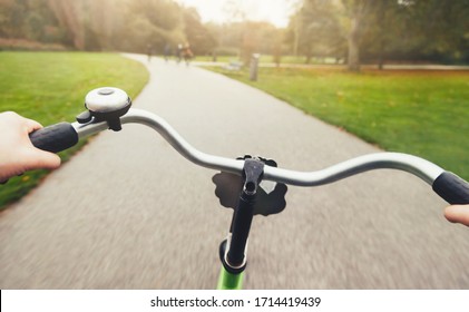 First-person view of cyclist in the rainy autumn city park. Rider's hands in on a bicycle handlebar. Motion blurred - Powered by Shutterstock