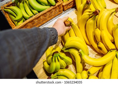 first-person view. man takes bananas in store. grocery shopping concept