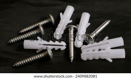 Fischer and screw set on black fabric mesh background