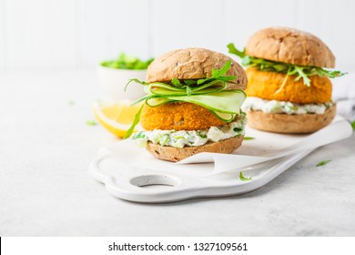 Fish Burger With Cucumber, Arugula And Mayonnaise Sauce, White Background, Vegetarian Food.