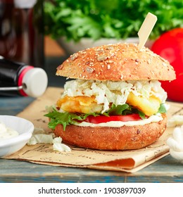 Fish burger. Delicious burgers with fried white fish (cod, pollock, perch, hake), tomatoes, lettuce, cabbage with tartare sauce on a whole-grain bun. Fast food for beer. Selective Focus