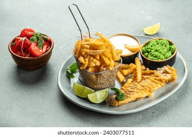 Fish and Chips with green mushy peas, vegetable salad, tartar sauce, Traditional English Food, recipe background. Close up, - Powered by Shutterstock