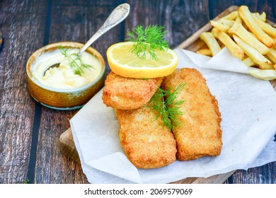  Fish and chips.Close up of crispy breaded  deep fried alaska pollock  fillets  with breadcrumbs served with remoulade sauce french fries  and  lemons
