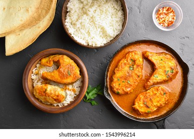 Fish Curry With Rice In Wooden Bowl On Black Stone Table. Indian Style Food. Top View, Flat Lay