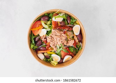 Fish Diet Salad With Tuna, Tomatoes, Arugula On Light Background Top View. Healthy Lunch. Eco-friendly Carton Packaging, Environment Protection. Food Delivery In Disposable Plate Of Craft Paper.