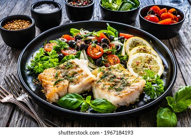 Fish Dish - Fried Cod Fillet With Fresh Vegetable Salad On Wooden Table 