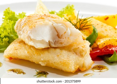 Fish dish - fried fish, fried potatoes and vegetables 