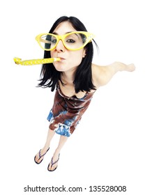 Fish Eye Lens View Of An Adult Woman In Her Early 30's, Wearing Funky Over Sized Glasses And Blowing A Party Horn Blower While Looking At The Camera With A Playful Gaze. Isolated On White Background.