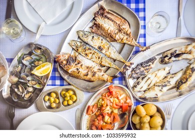 Fish Feast: Sea Bass, Golden, Horse Mackerel Accompanied With Tomato Salad, Clams, Bread And White Wine