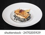 Fish fillet, breaded sea bass fillet with black fettuccine and beet sprouts, gourmet food