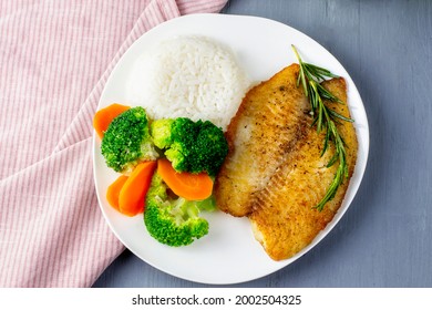 Fish fillet with rice and broccoli. White fish steak baked with vegetables and white rice. - Powered by Shutterstock