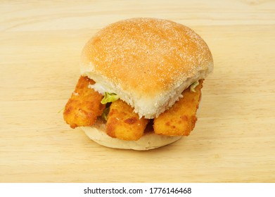 Fish Fingers In A Bread Roll On A Wooden Chopping Board