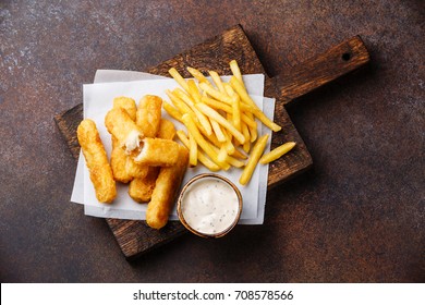 Fish Fingers And Chips British Fast Food With Tartar Sauce On Dark Background