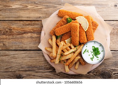 Fish Fingers And Fries With Sauce On Wooden Table. Top View.