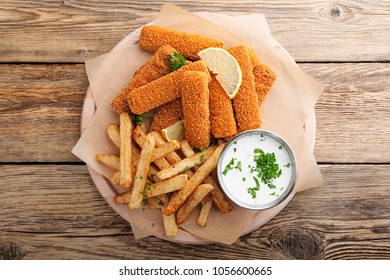 Fish Fingers And Fries With Sauce On Wooden Table. Top View.