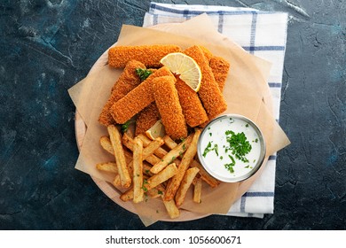 Fish Fingers And Fries With Sauce On Dark Background. Top View.