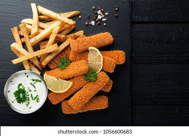 Fish Fingers And Fries With Sauce On Dark Background. Top View.