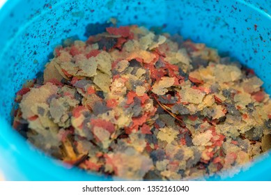 Fish Food Flakes In A Plastic Tub For Feeding Fish And Other Pets