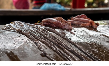 Fish Guts With May Flies On Stone Counter At The Street Fish Market.