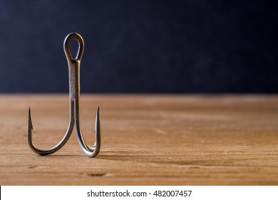 Fish Hook With 3 Hooks On A Wooden Background