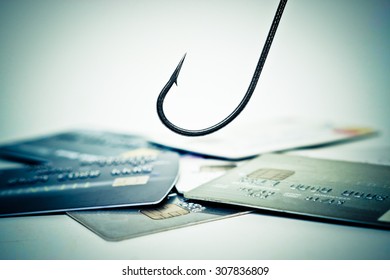 a fish hook over a pile of credit cards - credit card phishing