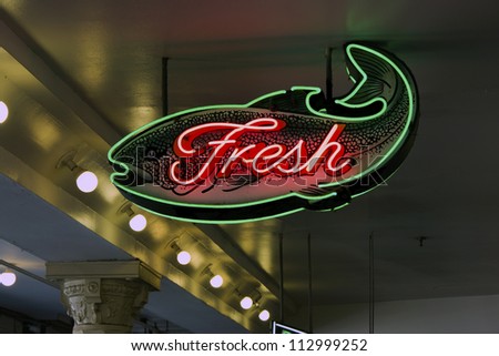 A fish neon sign mounted from the ceiling