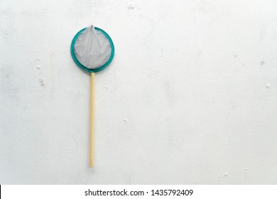 A Fish Net Hanging On The Old White Wall. Fish Net On The Wall.