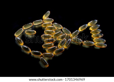 Fish oil capsules in fish shape with black background 