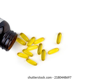 Fish Oil Capsules Spilling Out From The Bottle. Soft Gelatin Capsule Use In Pharmaceutical Manufacturing For Contain Oily Drug And Nutritional Supplement On Top View White Background.