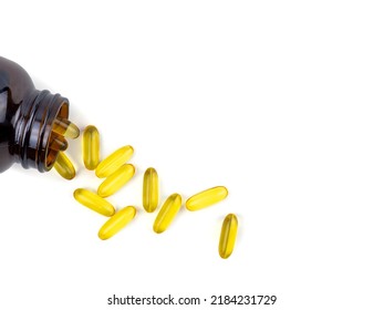 Fish Oil Capsules Spilling Out From The Bottle. Soft Gelatin Capsule Use In Pharmaceutical Manufacturing For Contain Oily Drug And Nutritional Supplement On Top View White Background.