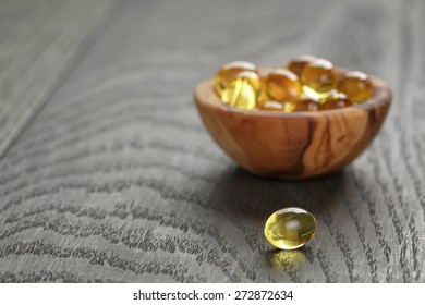 Fish Oil Capsules In Wood Bowl On Wooden Table