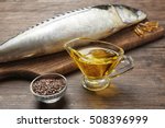 Fish oil with flax grain and fish on wooden background