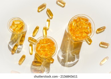 Fish Oil Gelatin Capsules In Laboratory Transparent Flasks On A White Background.Healthy Eating And Food Supplements.omega Fatty Acids. Flying Capsules Fish Oil.Natural Supplements And Vitamin