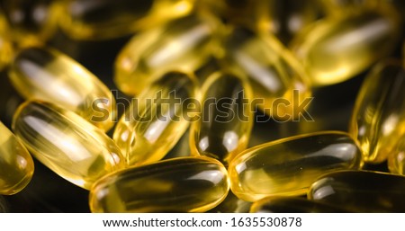 Fish Oil Omega 3 golden capsules on black blackground