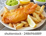 fish and potato chips served with a side of mushy peas  classic british english takeaway