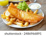 fish and potato chips served with a side of mushy peas  classic british english takeaway