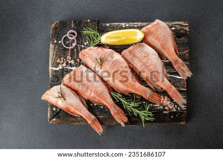 Fish red snapper on a wooden cutting board on a dark background. Healthy food concept. place for text, top view.