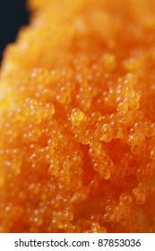 Fish roe on sushi roll. Tobiko. Close up.