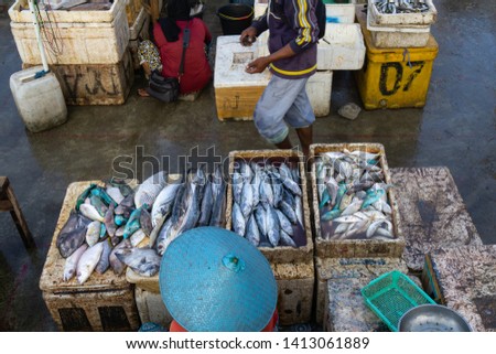 A fish sellers in the jimbaran bali fish market. He sells various types of fresh fish that have just been caught