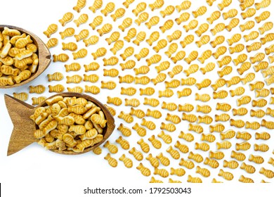 Fish Shaped Bowl Full Of Goldfish Crackers Chasing Little Fishes. Business Or Presentation Background Or Texture.