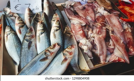 Fish and squid for sale at a seafood fishmonger's open-air market stall - Shutterstock ID 1298804908