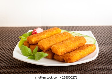 Fish Sticks With Vegetables On A White Plate