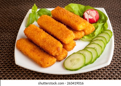 Fish Sticks With Vegetables On A White Plate