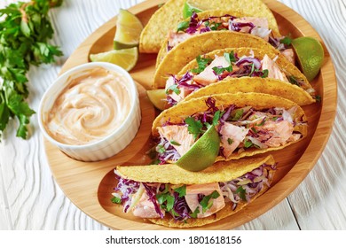 Fish Tacos With Red Cabbage Salad With Spicy Yogurt Sauce Sprinkled With Finely Chopped Parsley Served On A Bamboo Plate On A White Wooden Table, Horizontal View From Above, Close-up